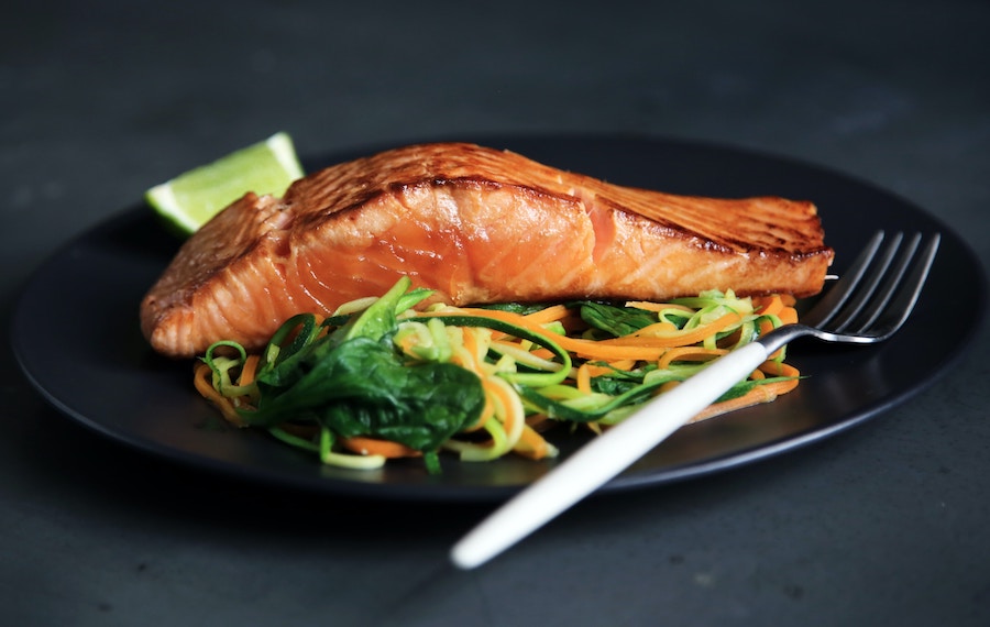 Um pedaço de salmão em um prato com salada