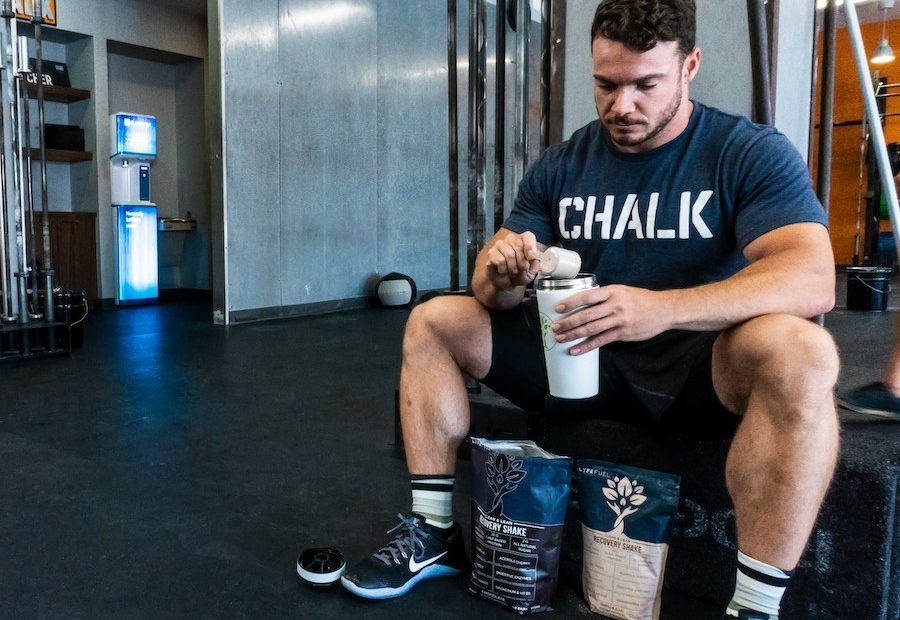 Homem preparando um shake de whey e creatina na academia